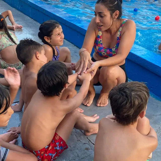 Una profe enseñando a nadar en la pileta